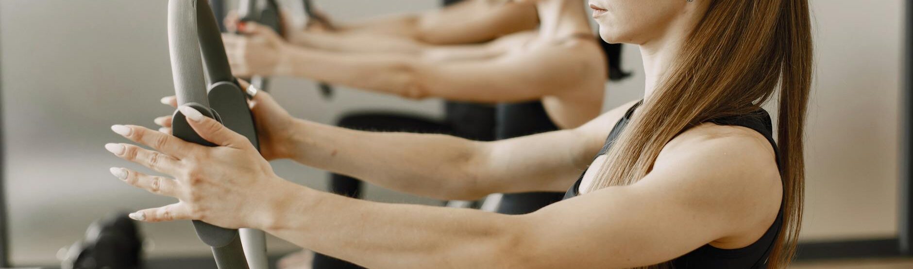woman in black sports bra holding a pilates ring